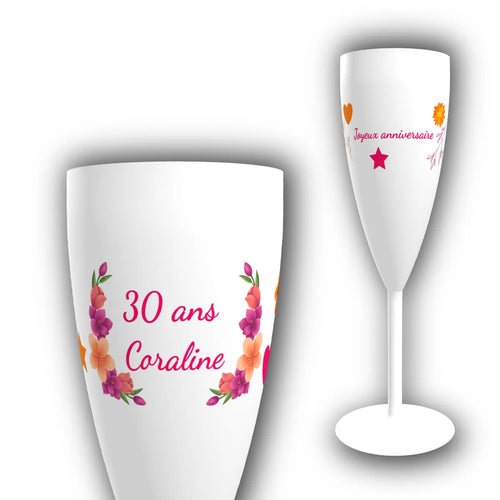 Flûte à champagne personnalisée avec couronne de fleurs tropicales roses et oranges, prénom et âge inscrits en rose vif pour un anniversaire